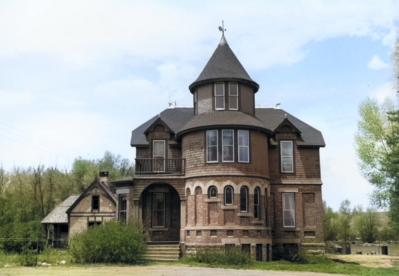 Colorized Hartman Caslte Colorized image of the Hartman Castle in Gunnison, Colorado from the front with green trees and blue skies surrounding the brown brick, Victorian home.